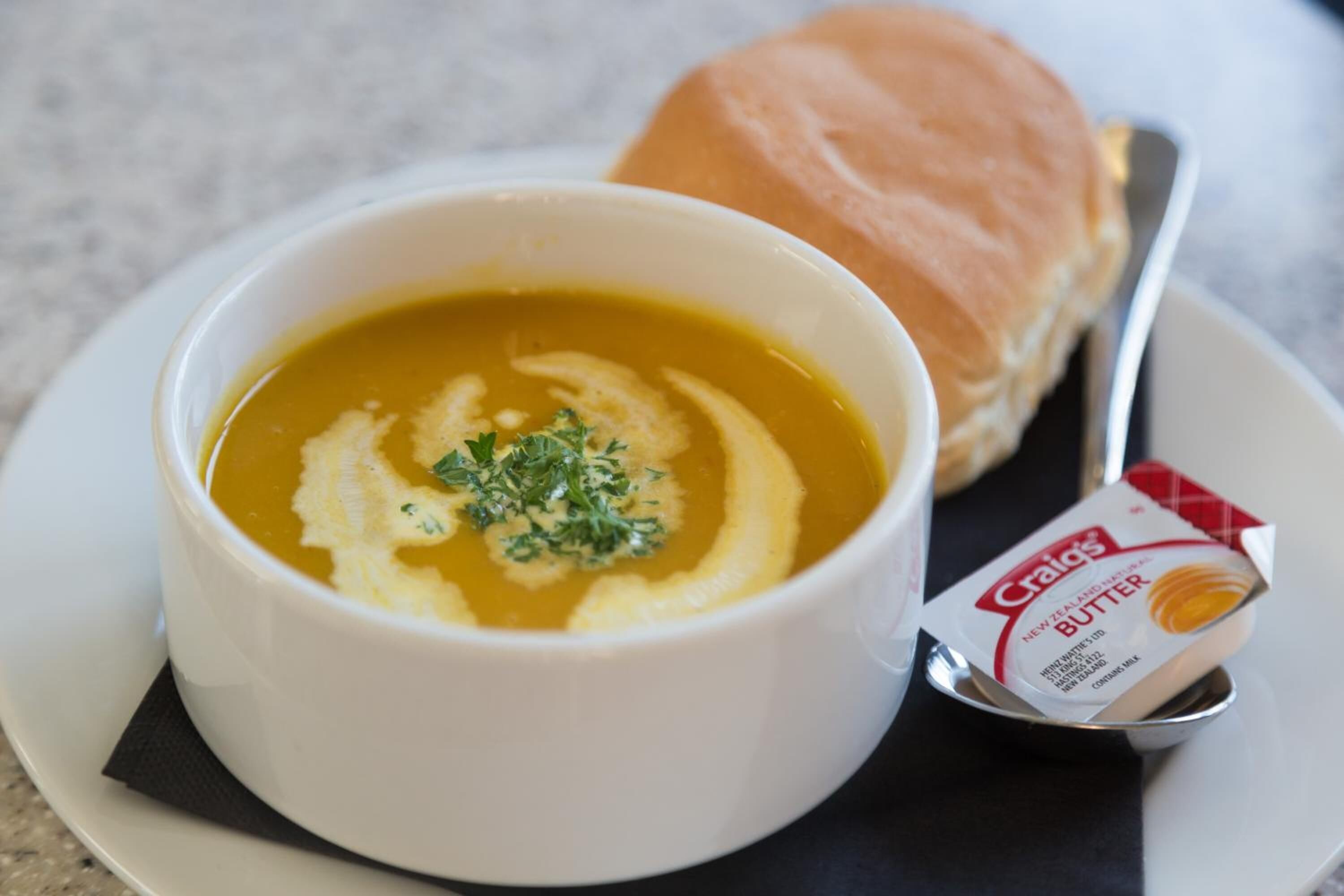 Un bol de sopa amb un paquet de mantega a la vora.