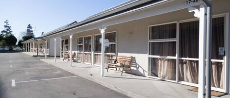 A row of motel rooms with individual balconies, numbered 17-20, and a parking lot in front.