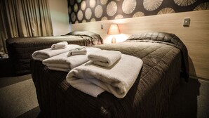 Een hotelkamer met een bed, een stoel en een lamp.