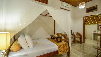 Una habitación con cama, una silla, una mesa y una lámpara colgante.