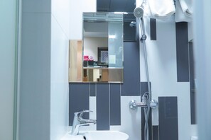 A modern bathroom with a sink, mirror, and shower. - Shanghai Red (Kowloon)