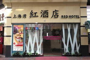 A hotel entrance with a large sign reading "Red Hotel". - Shanghai Red (Kowloon)