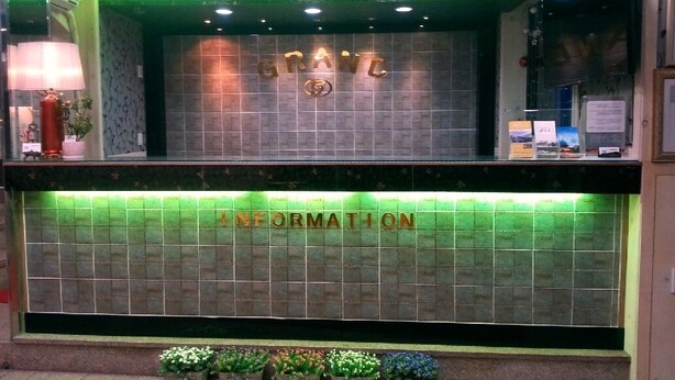 A reception desk with a tiled wall and a green-lit information counter. - Songnisan Grand Hotel & Condo (Boeun)