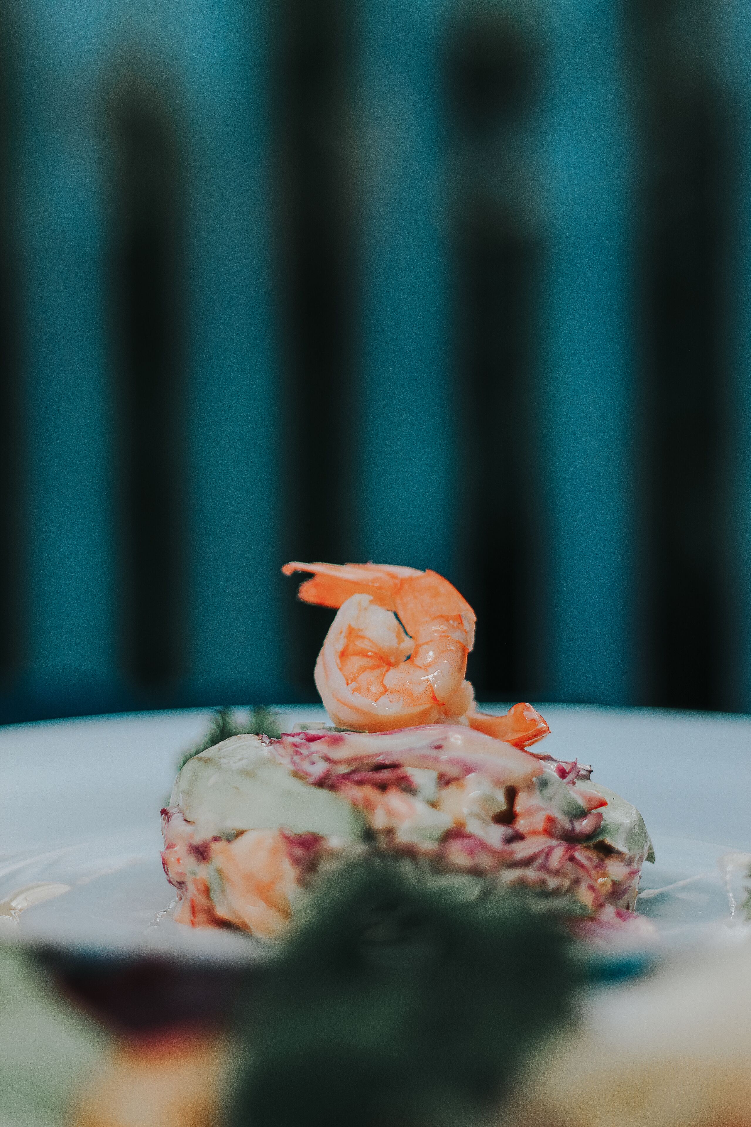 Une assiette avec une crevette et une salade.