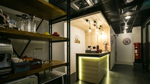Uma cozinha moderna com bancada de madeira, micro-ondas embutido e máquina de café.