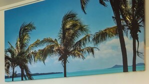 Een bed met witte kussens, een groene dekbedovertrek en een houten hoofdbord.