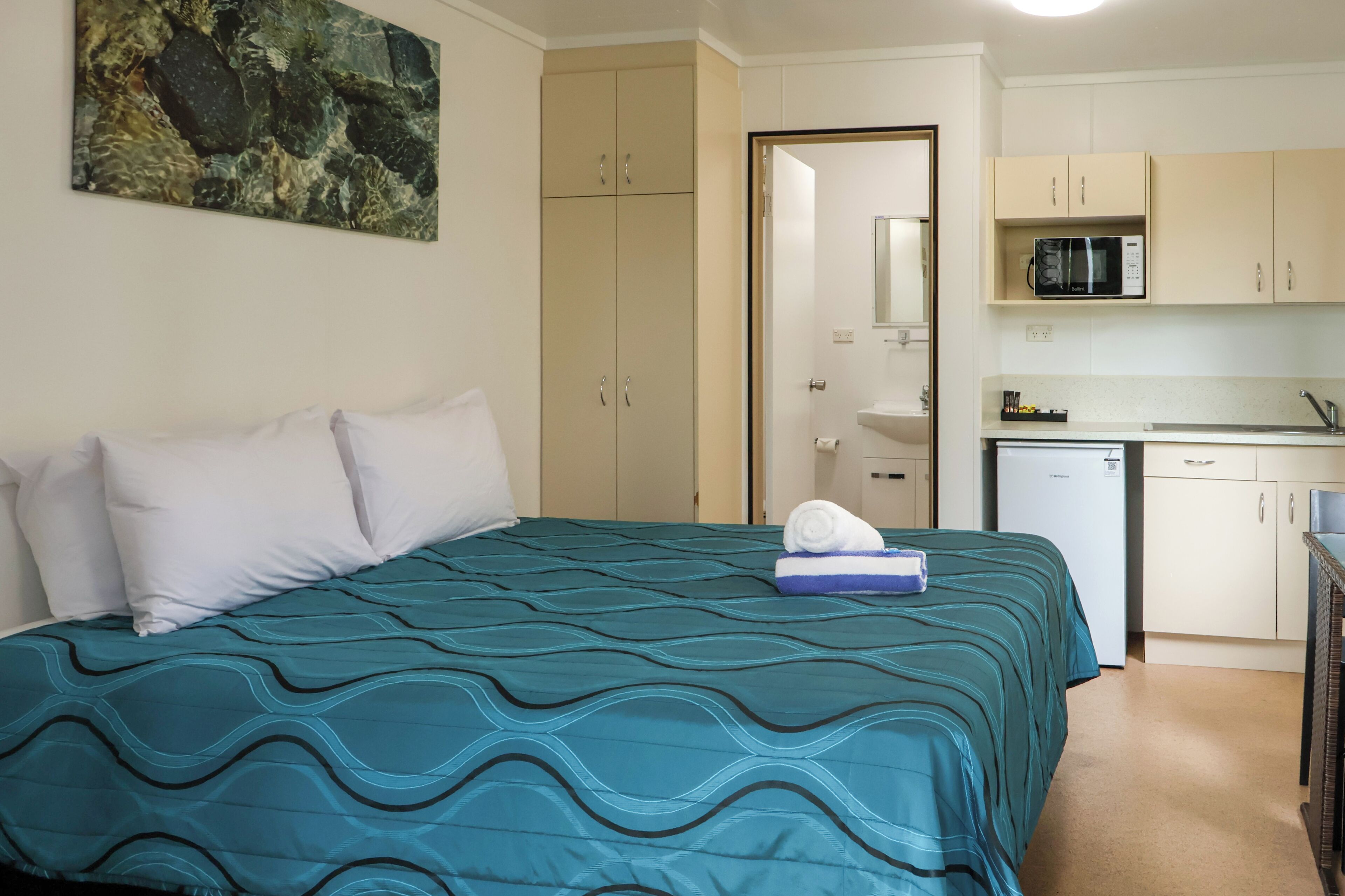 Un dormitorio con cama, baño y kitchenette.