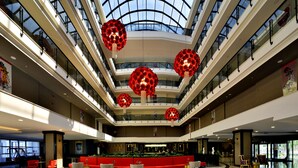 A multi-level atrium with a central seating area, glass railings, and decorative spherical chandeliers. - Seaden Valentine Resort & Spa - Adults Only - All inclusive (Manavgat)
