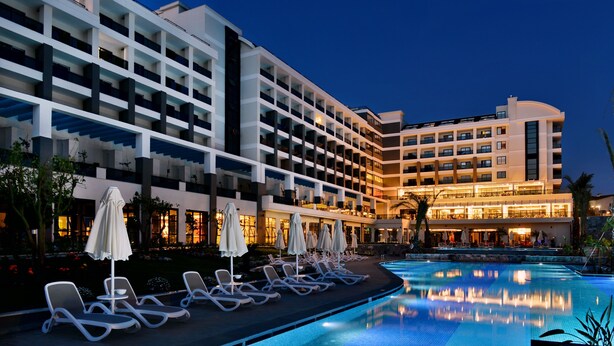 A hotel with a swimming pool, lounge chairs, and umbrellas. - Seaden Valentine Resort & Spa - Adults Only - All inclusive (Manavgat)