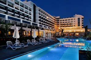 A hotel with a swimming pool, lounge chairs, and umbrellas. - Seaden Valentine Resort & Spa - Adults Only (Manavgat)