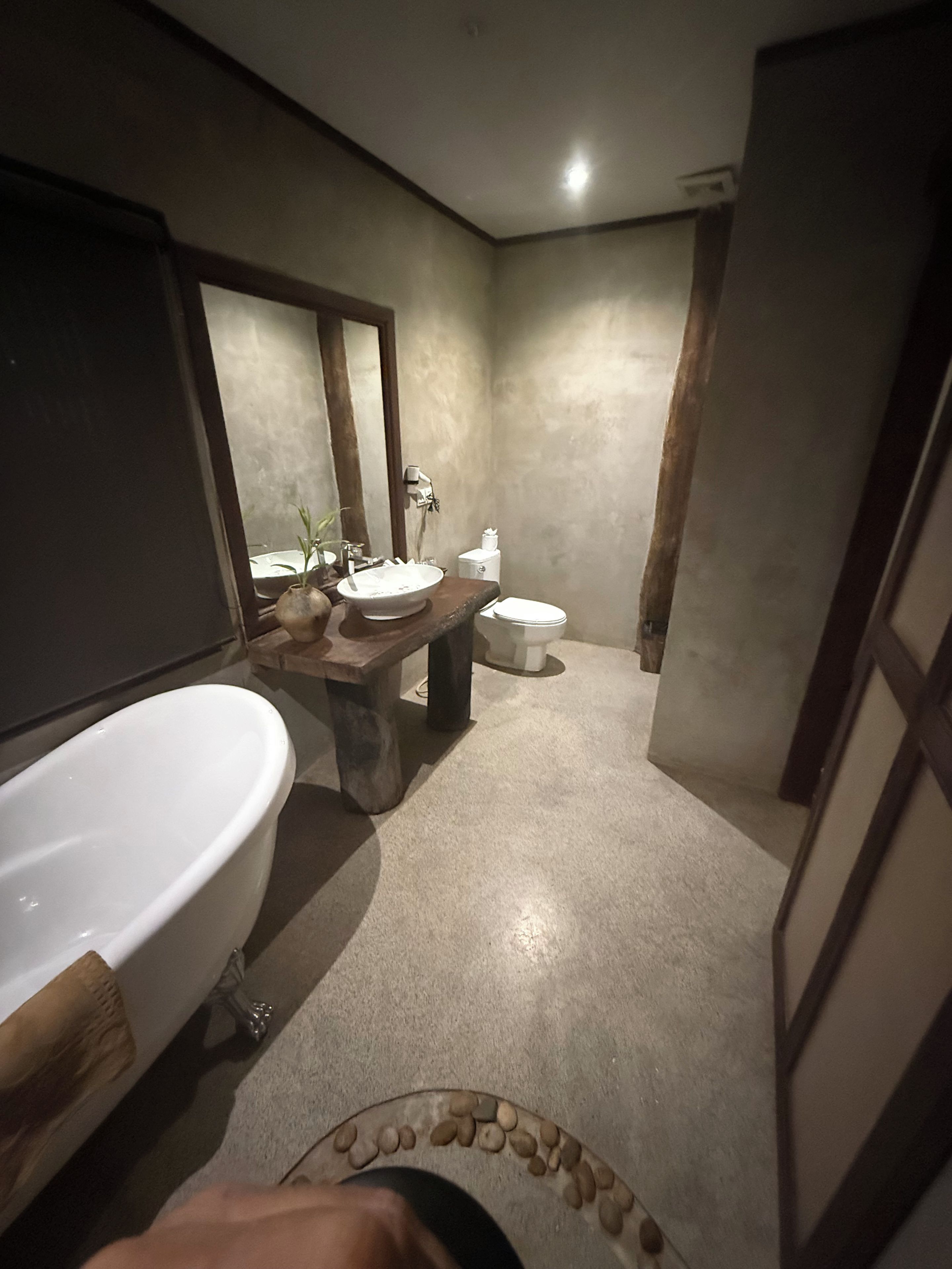 Een badkamer met een vrijstaand bad, een wastafel en een toilet.