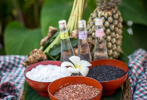 Una mesa con cuencos de granos y especias, una piña y botellas con etiquetas.