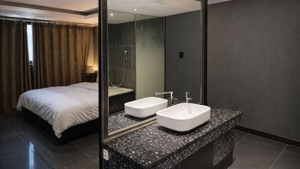 A modern hotel room with a large bed, two sinks, and a large mirror. - Zenith Hotel (Bucheon)