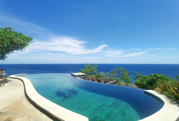 Una piscina al aire libre, sillones reclinables de piscina