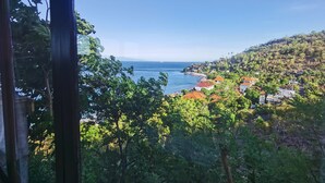A coastal town with houses and a clear view of the sea. - Wawa Wewe Rock (Karangasem)