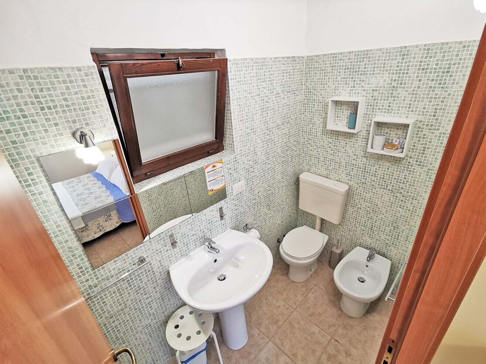 A small bathroom with a toilet, bidet, and sink.