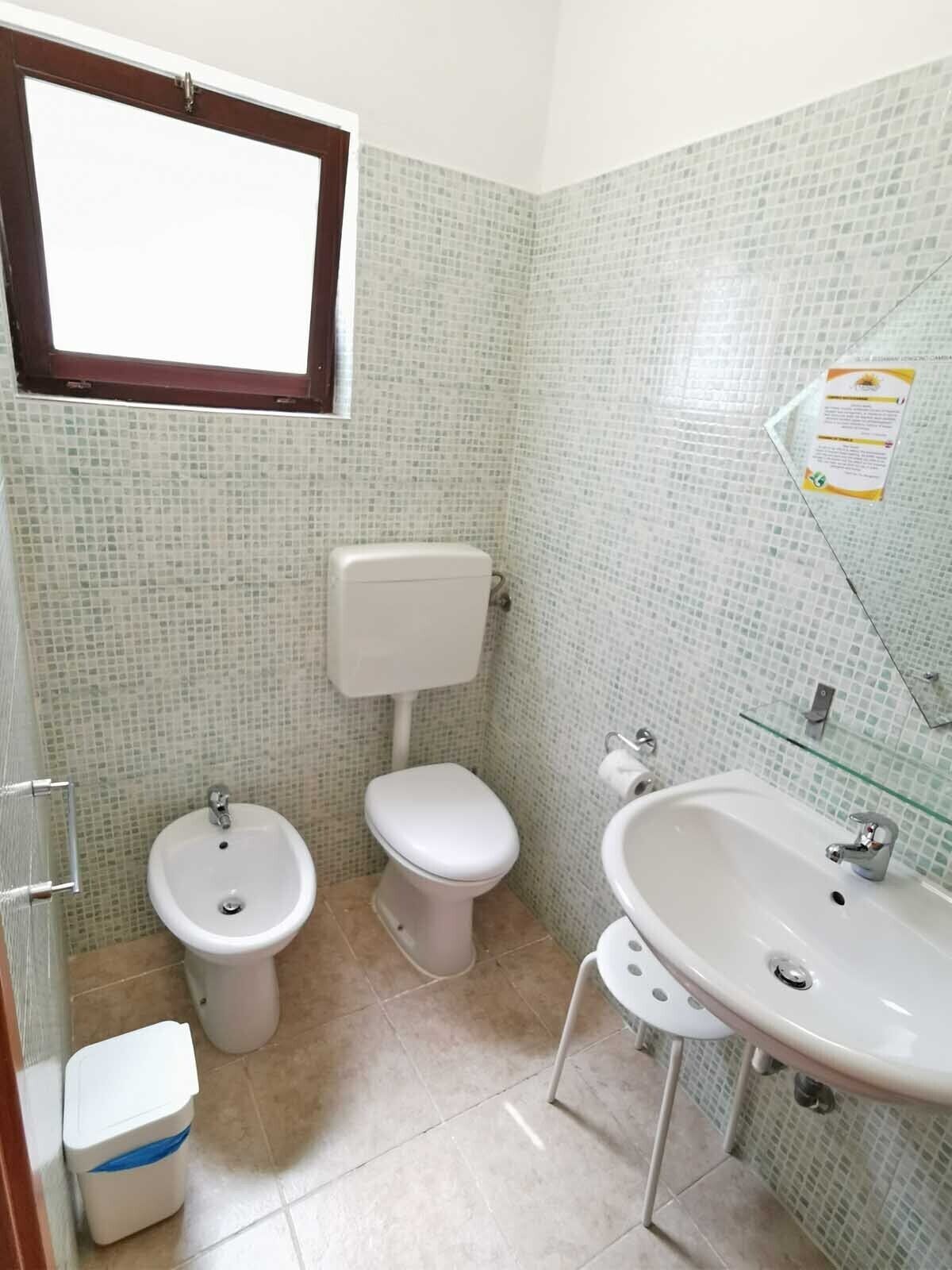Et lille badeværelse med toilet, bidet og vask.