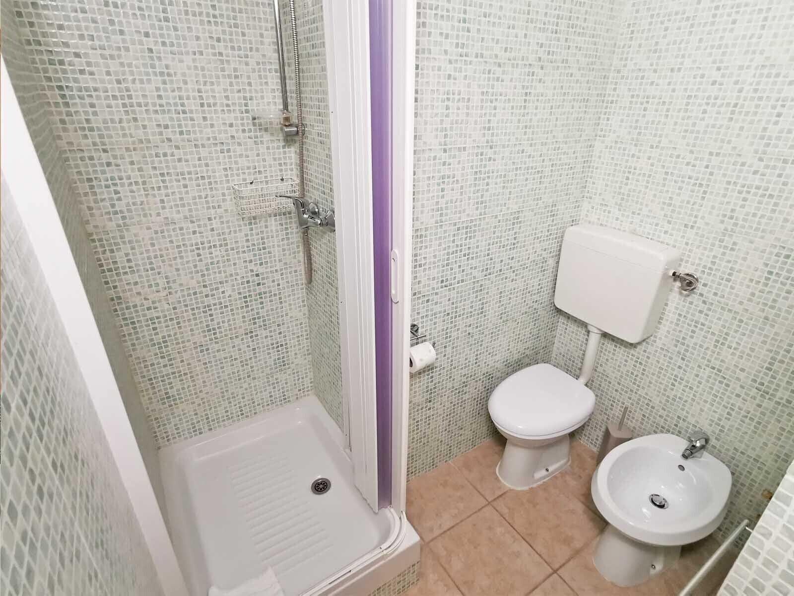 Un baño con ducha, inodoro y lavamanos.