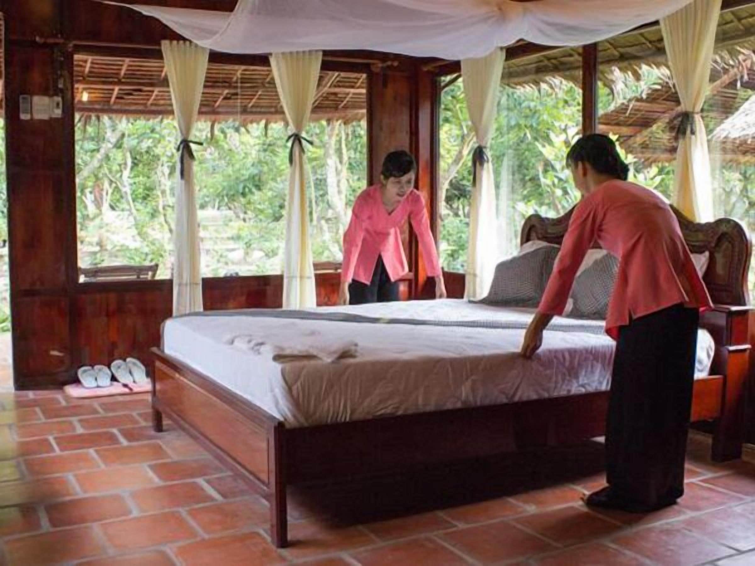 Una habitación de madera con una cama, un banco y un asiento de banco.