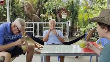 Trois personnes sont assises à une table à l'extérieur et savourent des boissons.