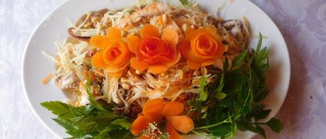 A plate of food with shredded vegetables, carrots, and parsley.