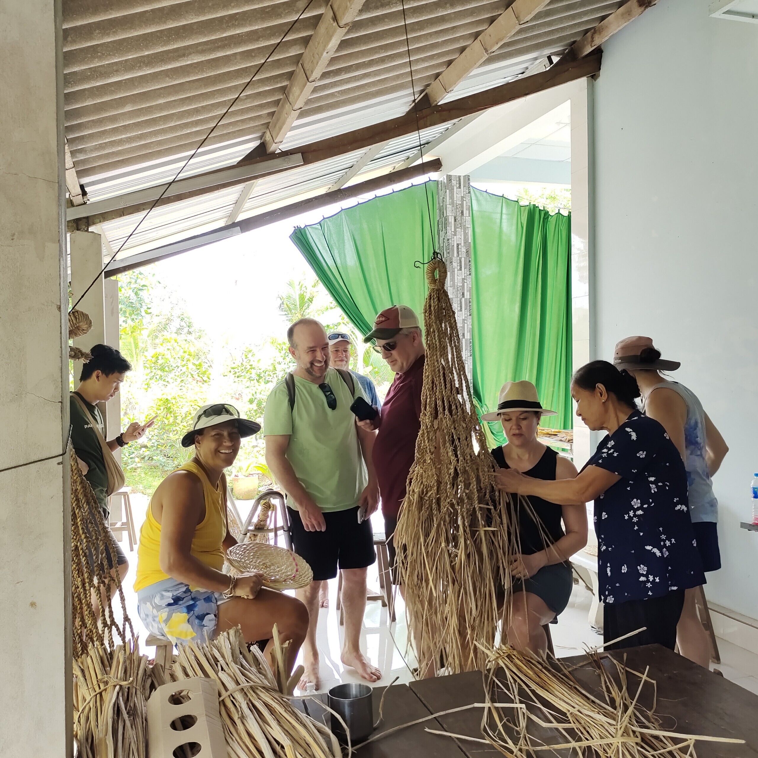A group of people gathered around a table with dried plant materials, possibly for a craft or educational activity.