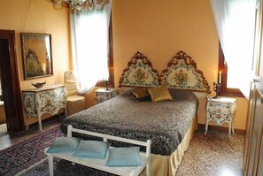 A bedroom with a bed, a nightstand, a dresser, a mirror, and a patterned rug.
