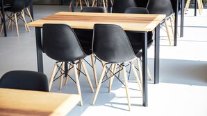 A modern classroom with wooden tables and black chairs. - B2 Udon Boutique & Budget Hotel (Udon Thani)