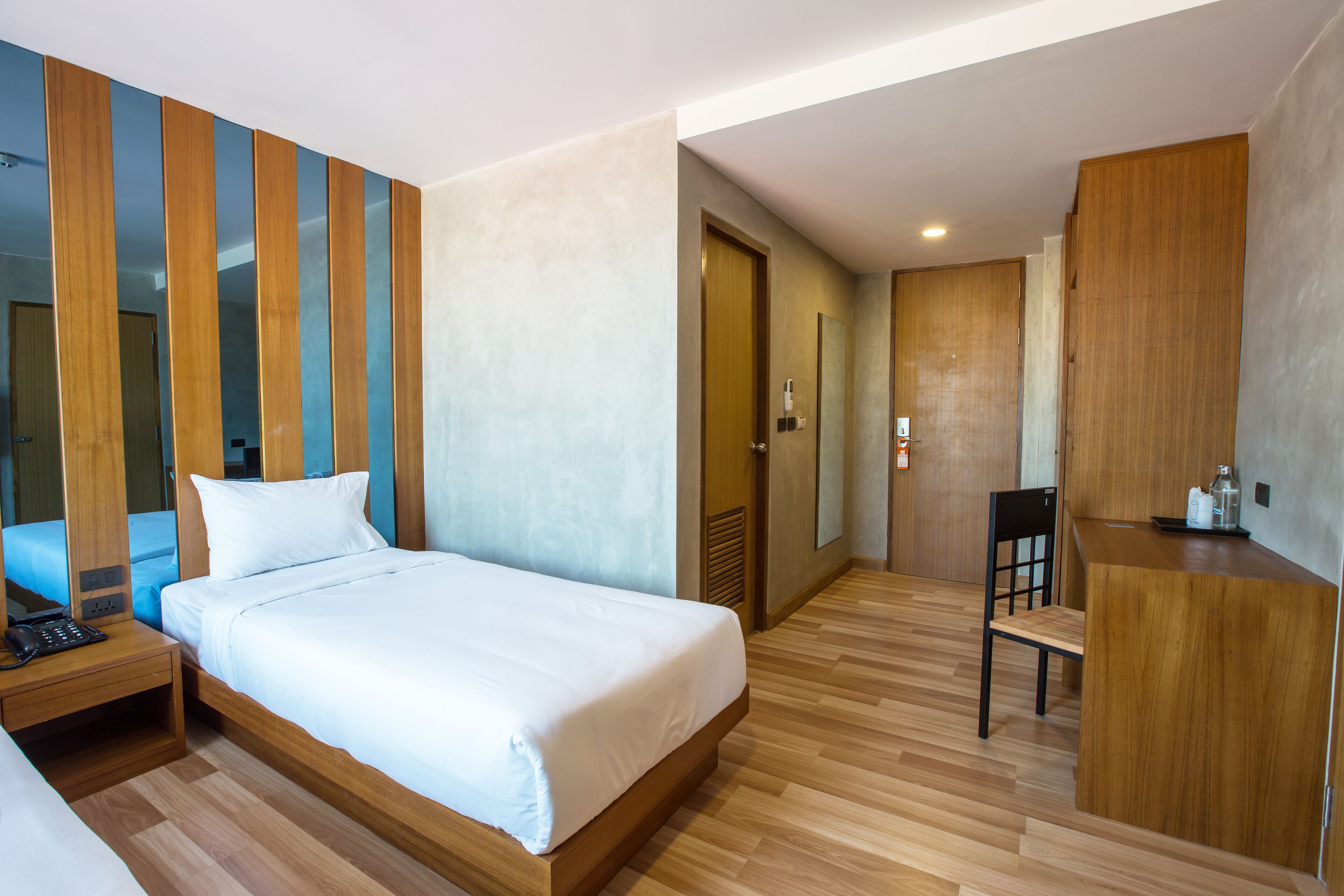 Una habitación de hotel con una cama de madera, un escritorio y una silla.