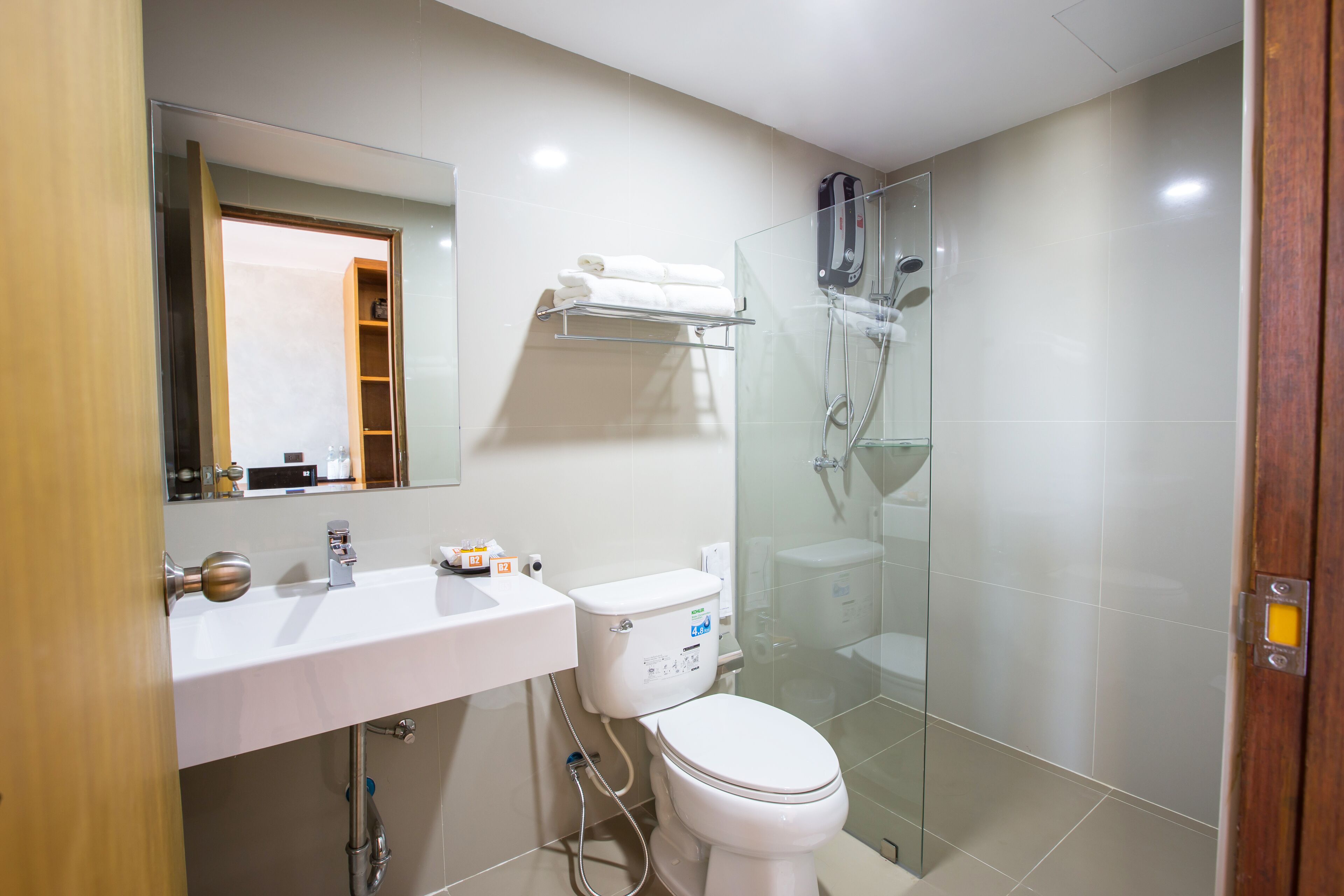 A modern bathroom with a glass-enclosed shower, a white sink, and a toilet.