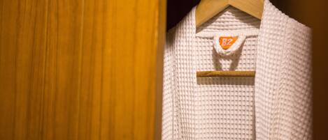 A white knitted garment hanging on a wooden hanger with a tag labeled "B2".