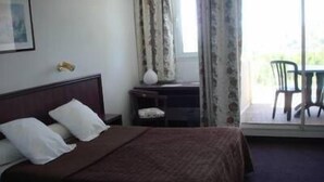 Una habitación de hotel con una cama, un escritorio pequeño y una silla.