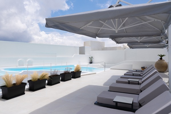 En säsongsöppen utomhuspool, parasoller och solstolar
