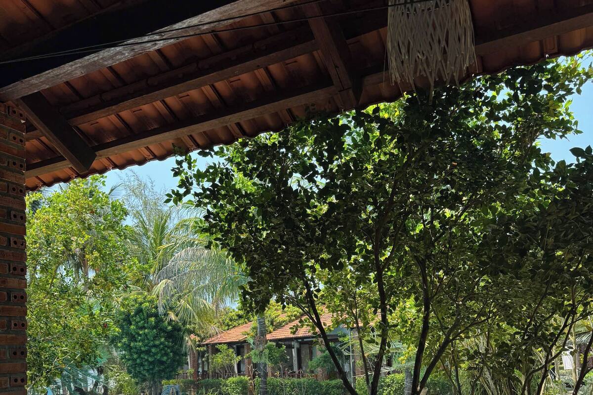 A pool with a wooden deck and a covered area with a hanging light fixture.