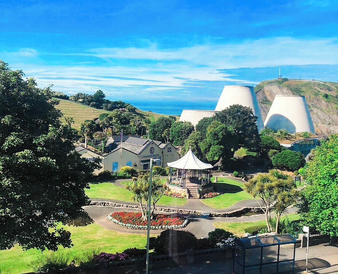 A coastal resort with a gazebo, landscaped gardens, and a view of the ocean.