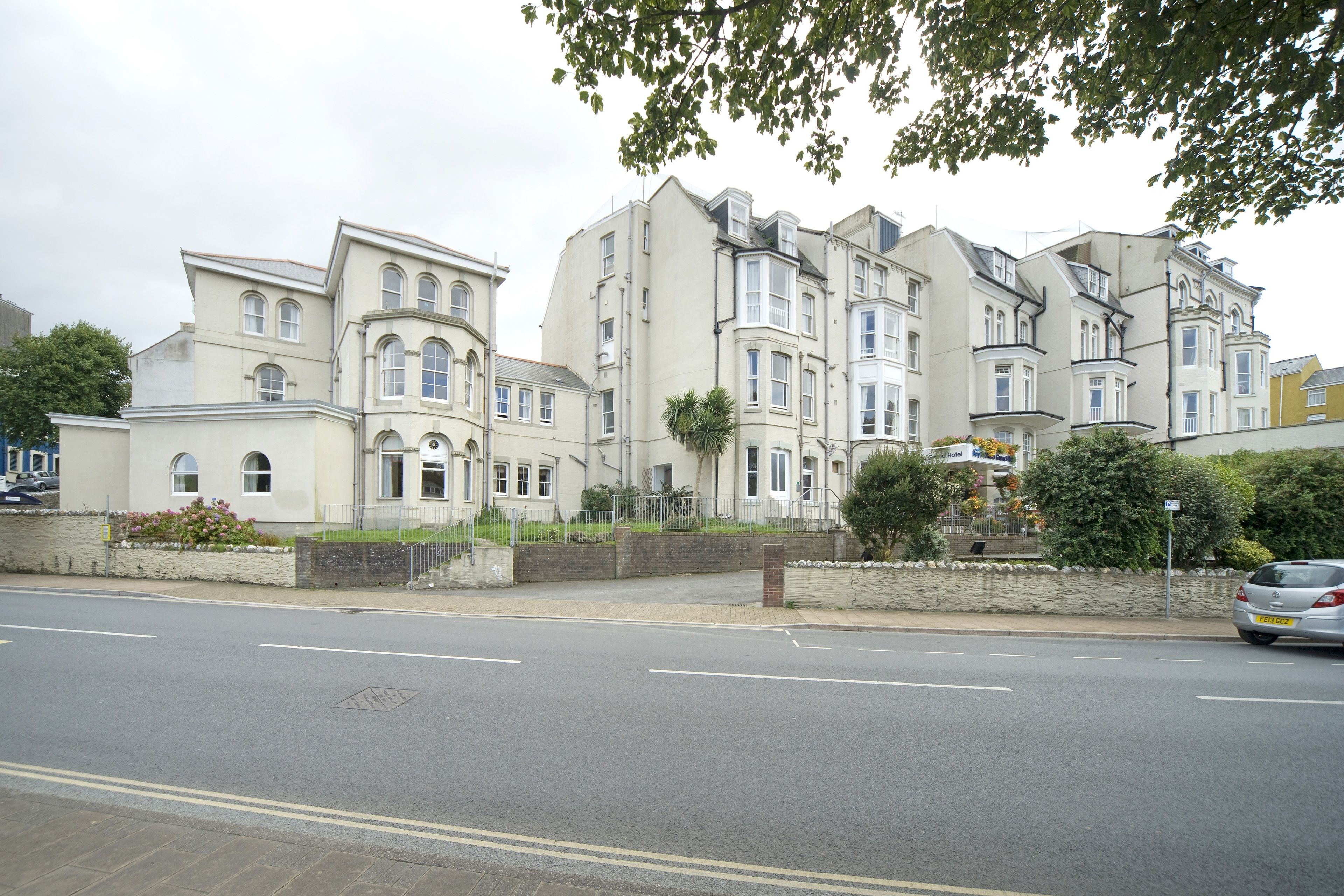A row of multi-story residential buildings with a street in front.