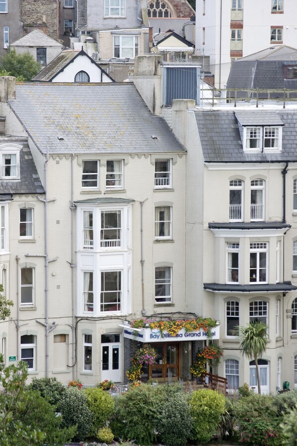 A multi-story hotel with a bay window and flower boxes.