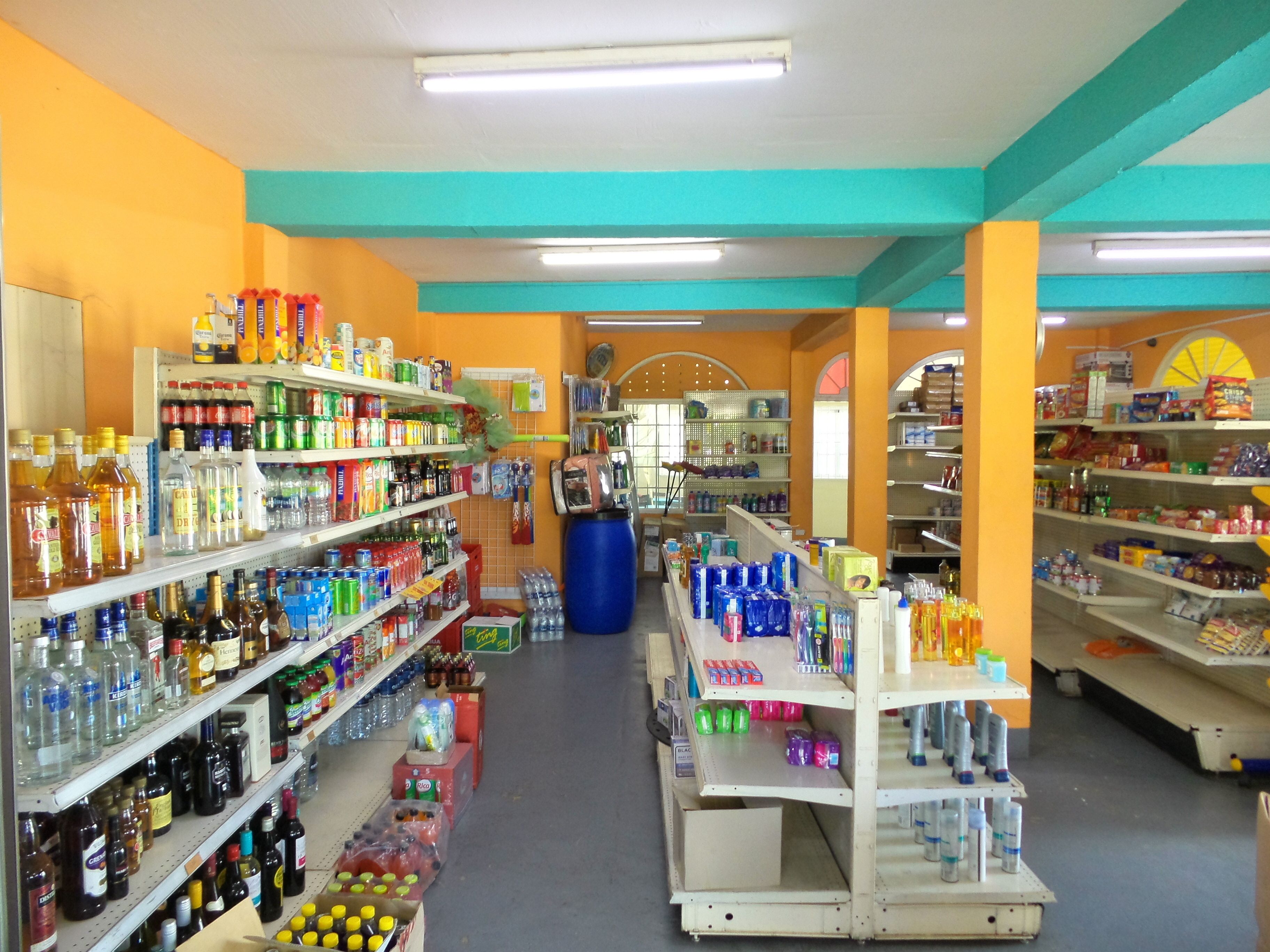 Tienda luminosa con estantes llenos de diversas bebidas y aperitivos.