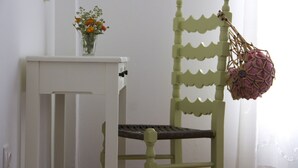 Una silla verde con un bolso tejido colgado del respaldo.