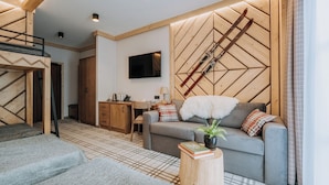 Ein modernes Wohnzimmer mit einer Couch, einem Couchtisch und einem an der Wand montierten Fernseher.