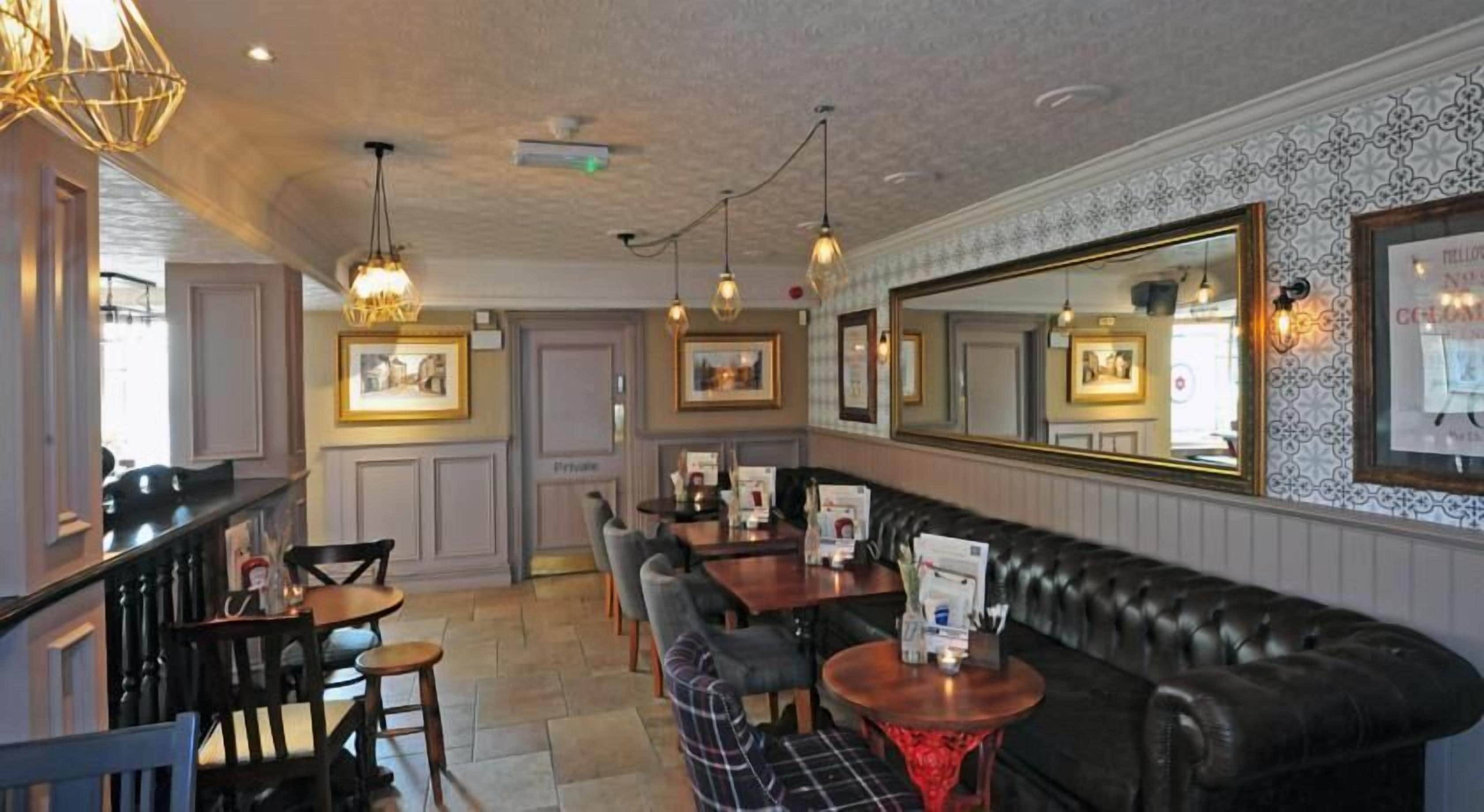 A restaurant with a bar area, a long counter, and a seating area with a sofa and chairs.