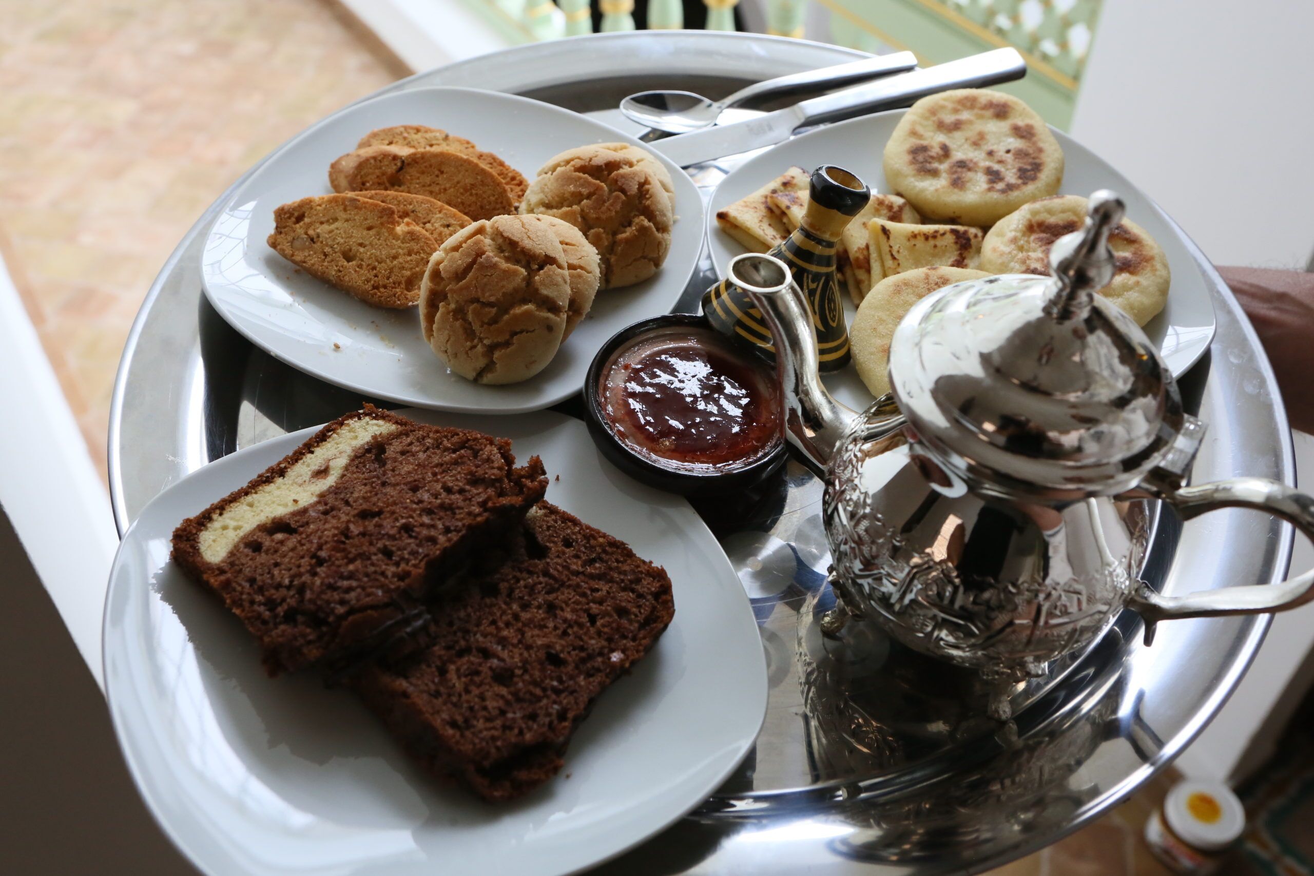 A tray with various pastries and a teapot.