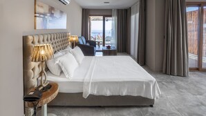 Hotellihuone, jossa on suuri sänky, yöpöytälamppu, puhelin ja näkymä parvekkeelle.