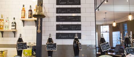 A bar area with various beer taps and shelves displaying bottles.
