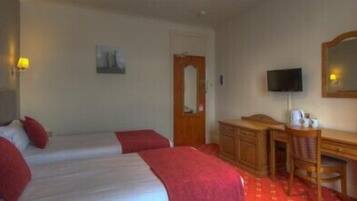 A hotel room with two beds, a desk, a chair, a television, and a mirror.
