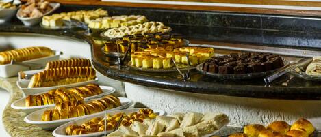 A buffet with various food items including bread, pastries, and desserts.