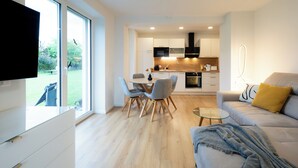 A modern kitchen with white cabinets, a black microwave, and a built-in oven. - Apartments Jesse (Sankt Kanzian am Klopeiner See)