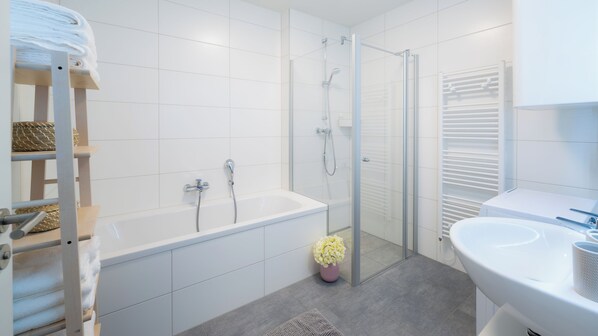 Un baño moderno con bañera, ducha e inodoro.