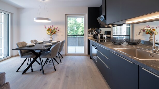 A modern kitchen with a dining area, large windows, and a view of the outdoors. - Apartments Jesse (Sankt Kanzian am Klopeiner See)