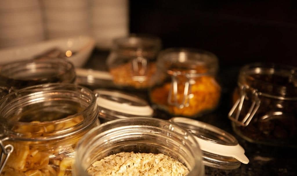 On peut voir une variété d’aliments présentés dans des récipients en verre, probablement dans le cadre d’un buffet ou d’un espace en libre-service.